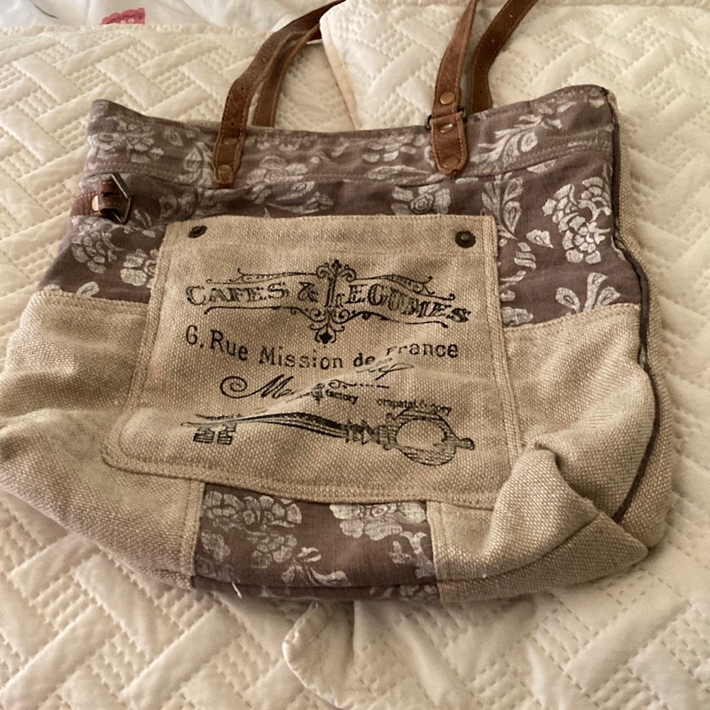 Myra bag, canvass with flower design, leather straps and pulls.
